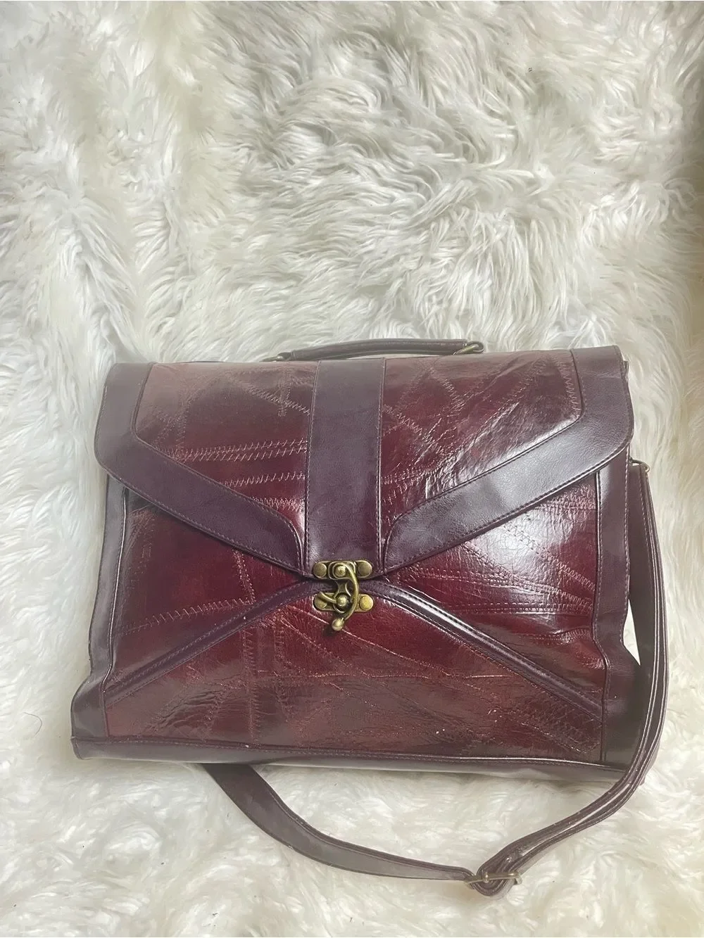 M.C textured leather patchwork like stitched accent burgundy leather bag .